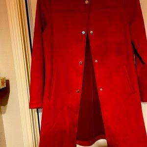 coat is a light weight to the knee burnt orange In  a soft ultra suede fabric